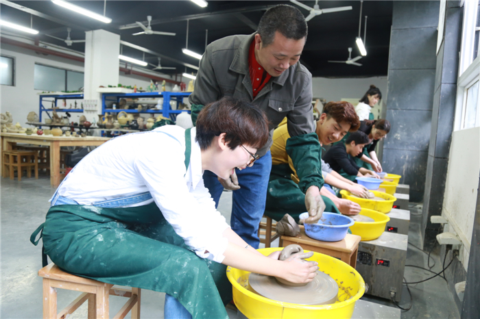 陶艺社同学在老师指导下练习拉胚
